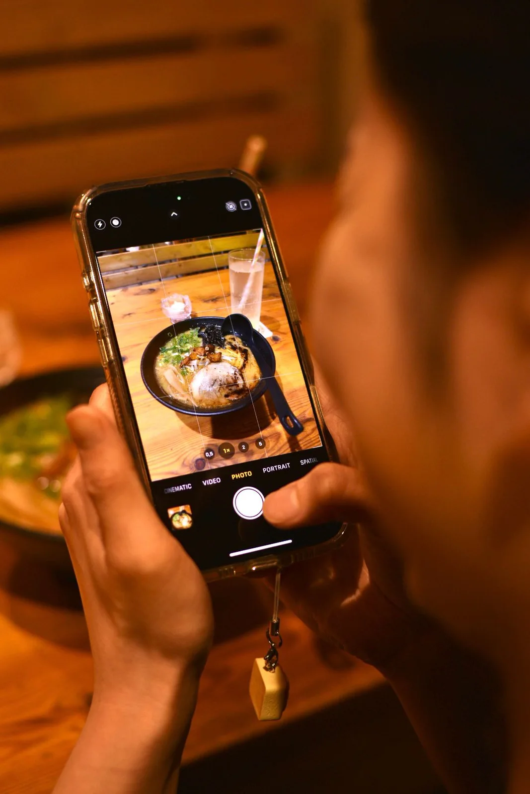 Guest photographing a bowl of ramen with a smartphone